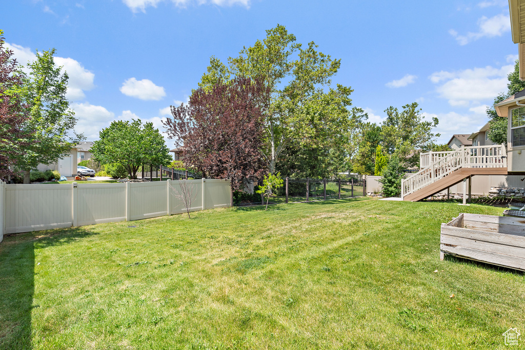 Fenced backyard featuring a deck and stairs