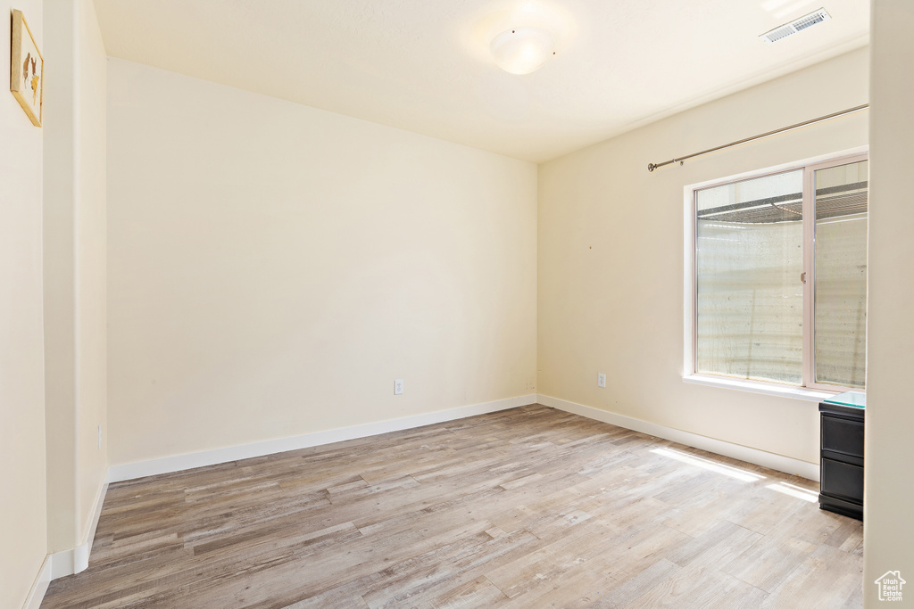 Spare room featuring light wood-type flooring and baseboards