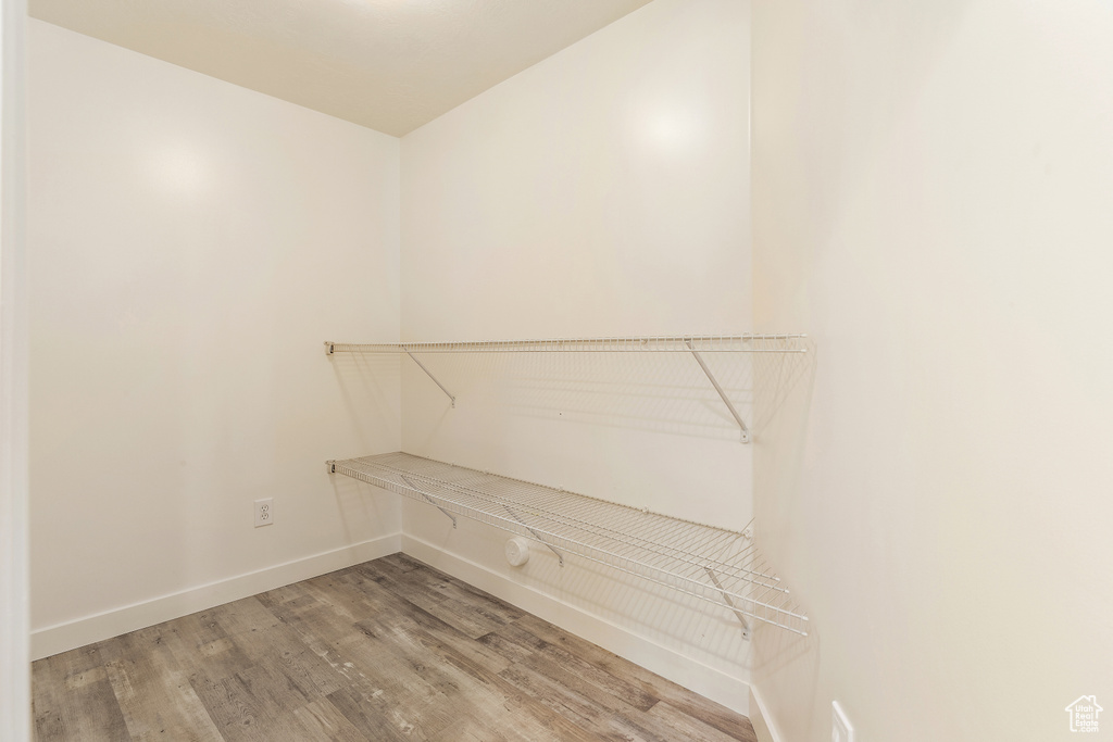 Walk in closet with light wood-style floors