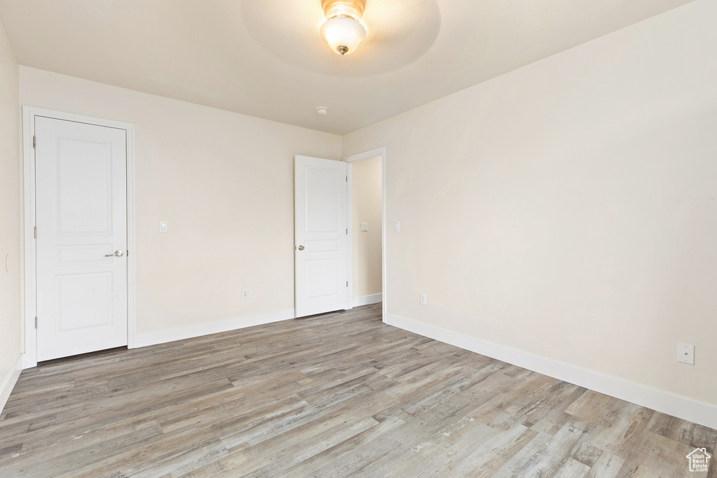 Spare room featuring light wood-style flooring and baseboards