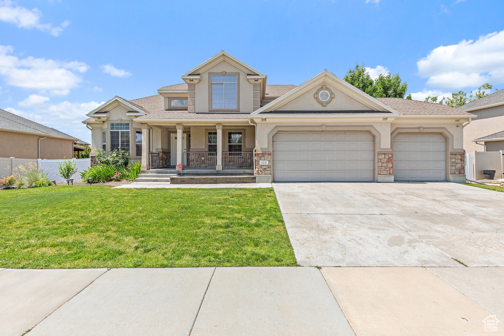 View of front of home featuring stucco siding, covered porch, driveway, and a garage