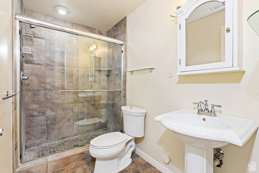 Bathroom featuring a shower stall and tile patterned flooring