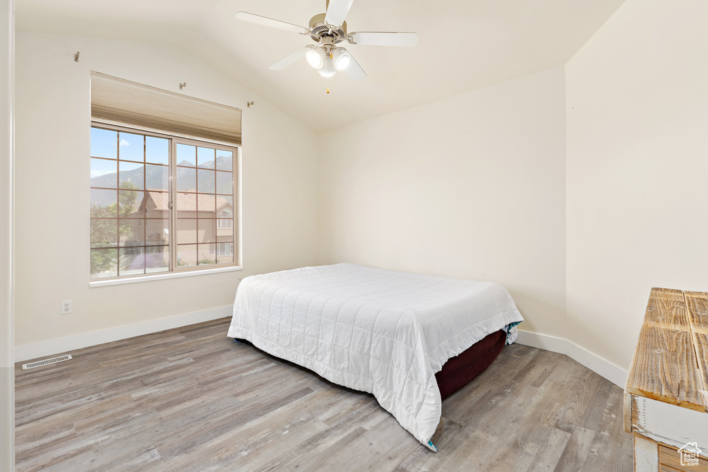 Bedroom featuring wood finished floors, lofted ceiling, and ceiling fan