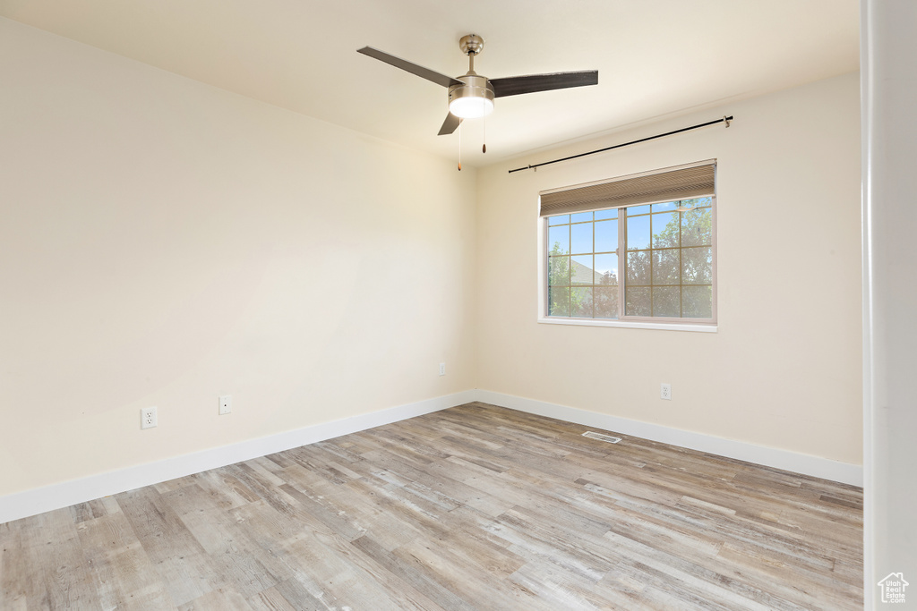 Empty room with wood finished floors and ceiling fan