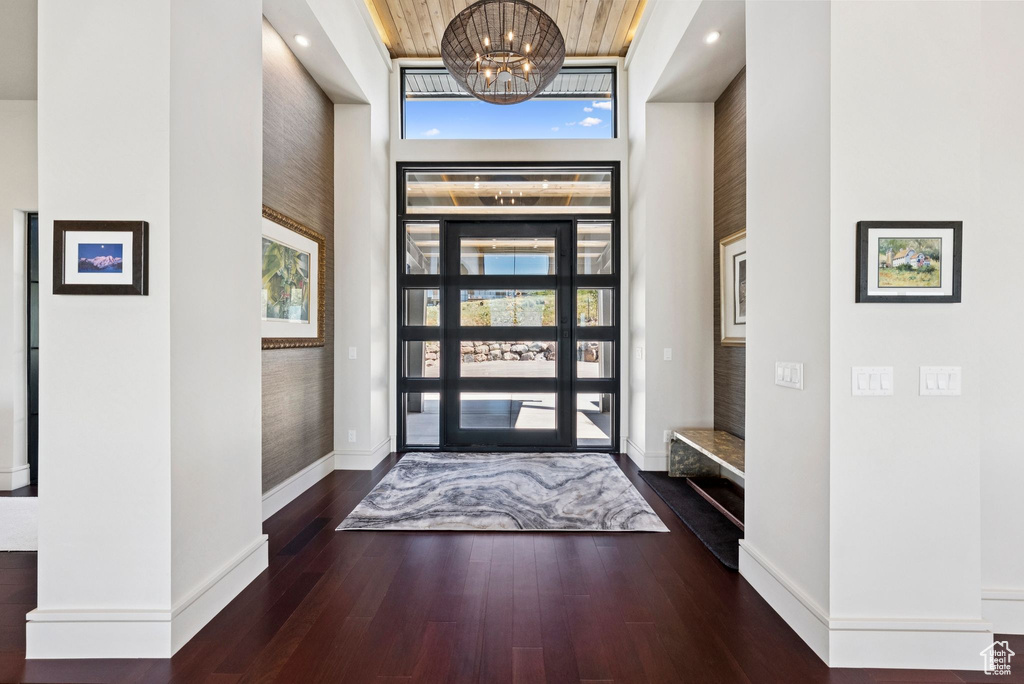 Entryway featuring a towering ceiling, wood finished floors, and a chandelier