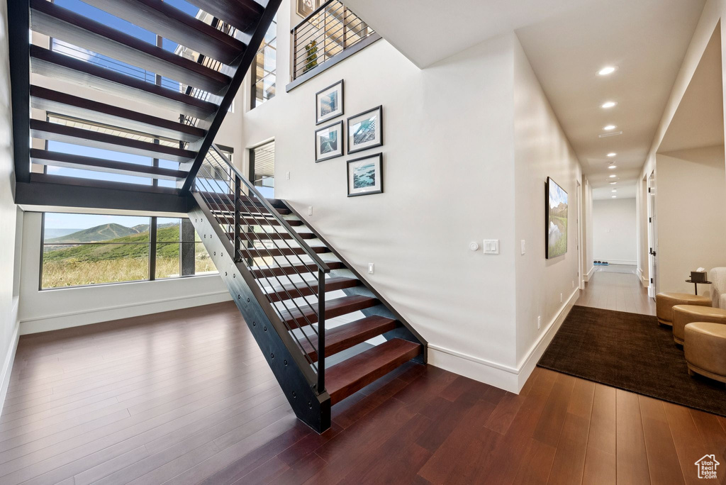 Stairway featuring wood finished floors and recessed lighting
