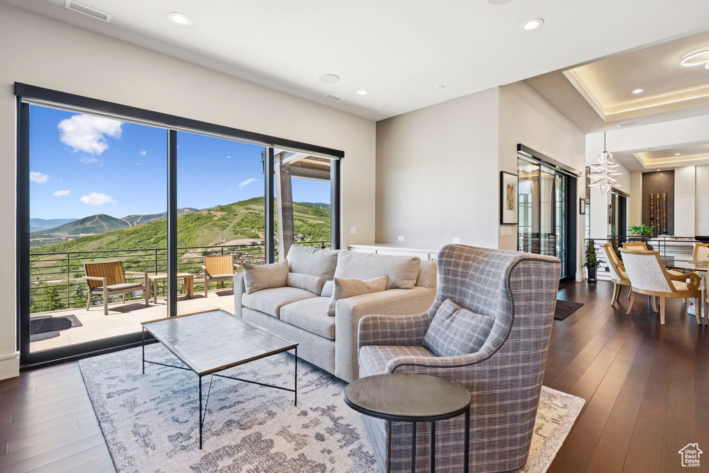 Living area featuring a mountain view, dark wood-type flooring, and recessed lighting
