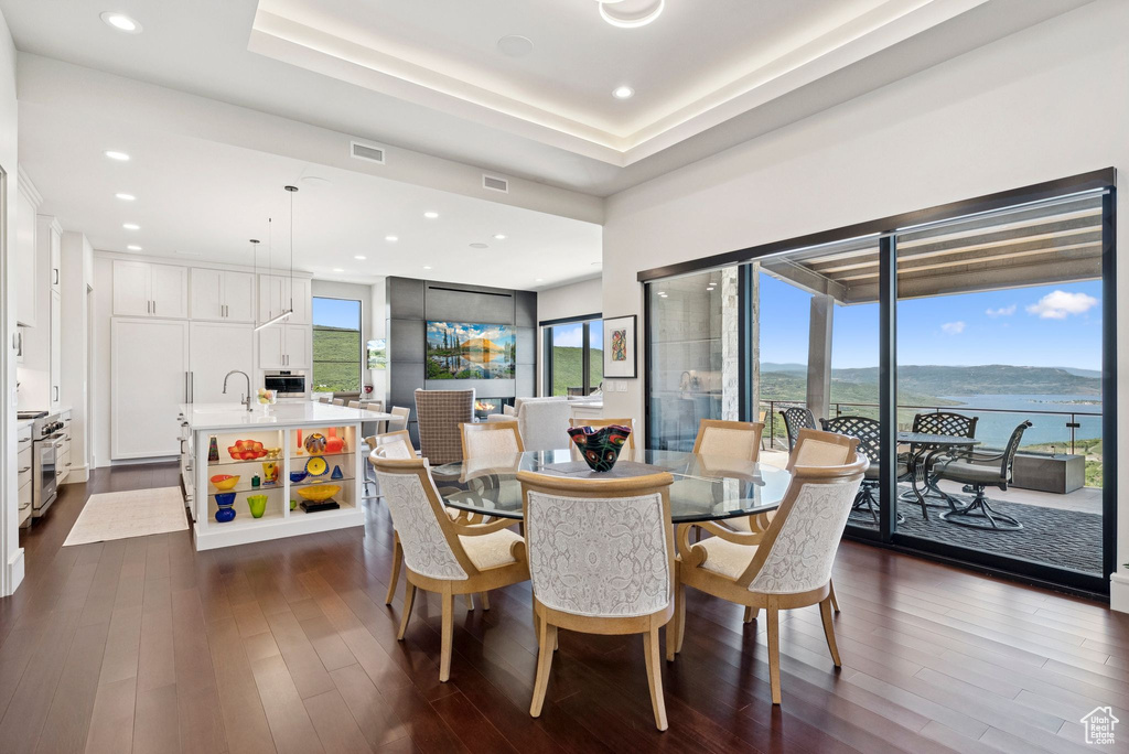 Dining room with dark wood-style flooring and recessed lighting