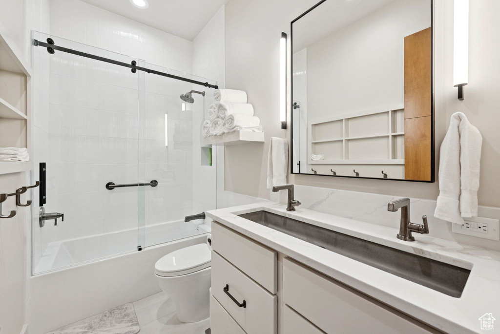 Full bathroom featuring vanity, bath / shower combo with glass door, and recessed lighting