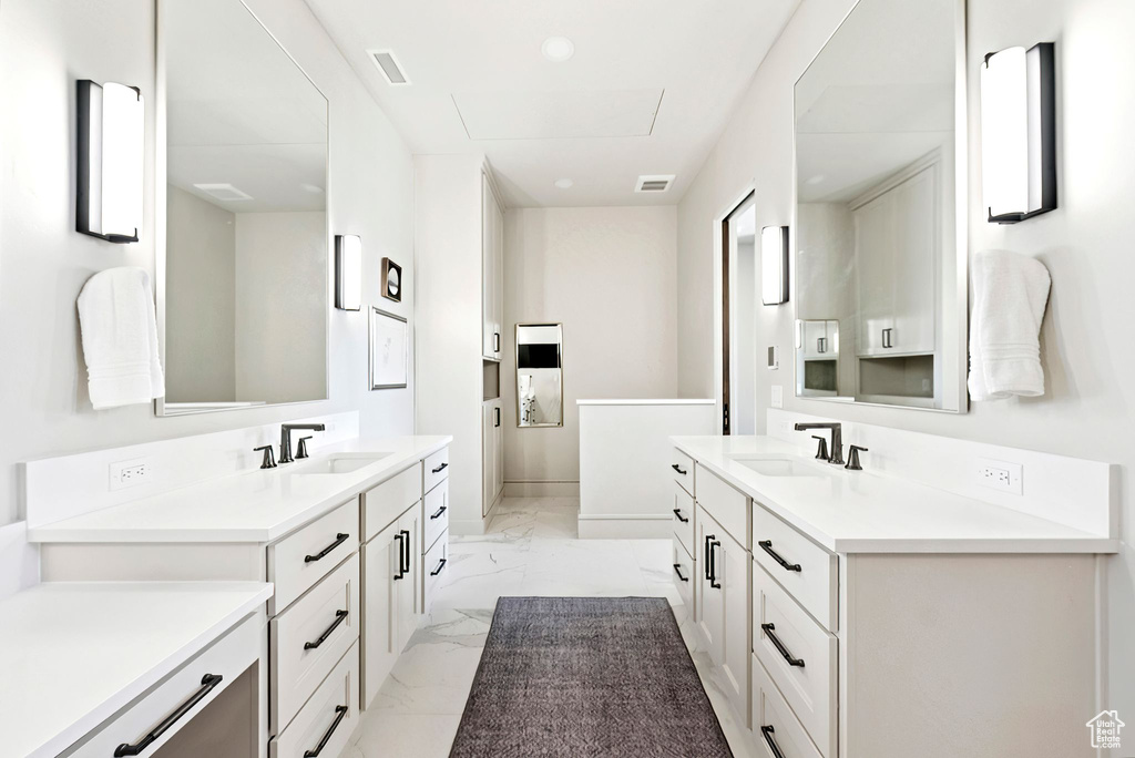 Bathroom with marble finish flooring and two vanities