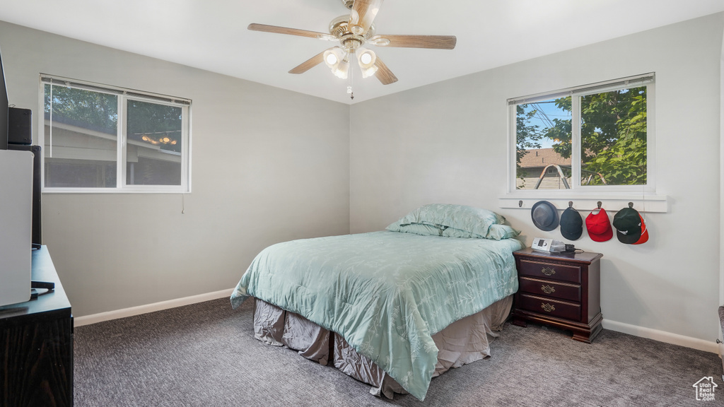 Carpeted bedroom featuring baseboards and ceiling fan