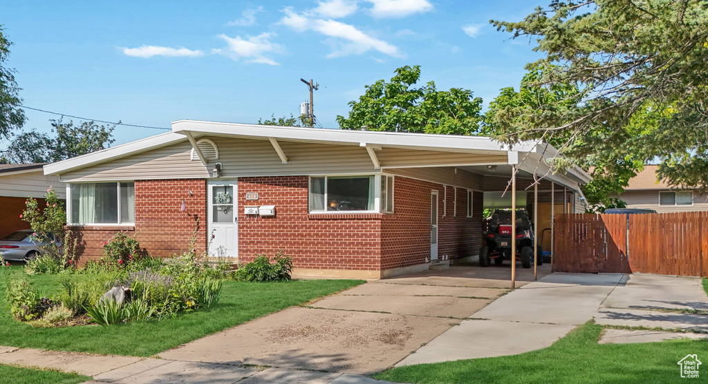 View of front of home with a carport, brick siding, and concrete driveway