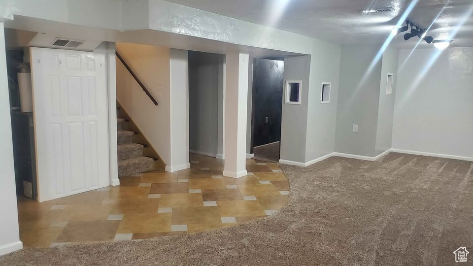 Finished basement with stairs and carpet flooring