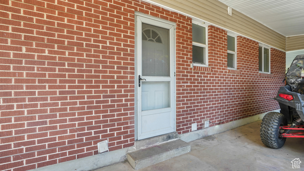 Doorway to property featuring brick siding