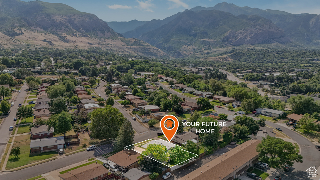 Aerial view of residential area featuring property boundaries highlighted and a mountainous background