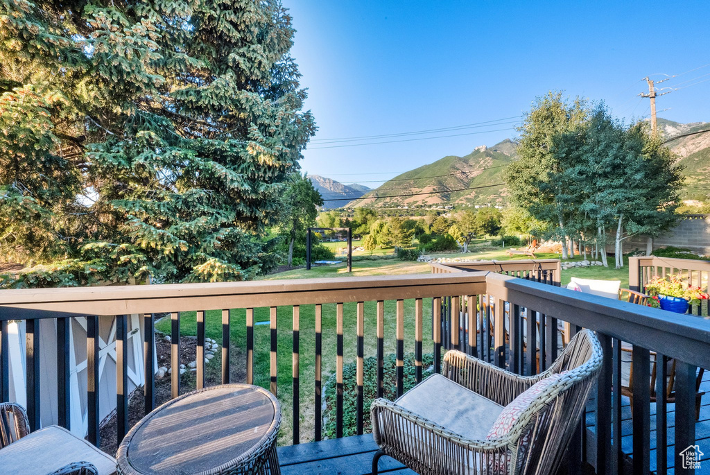 Wooden deck with a mountain view and a lawn