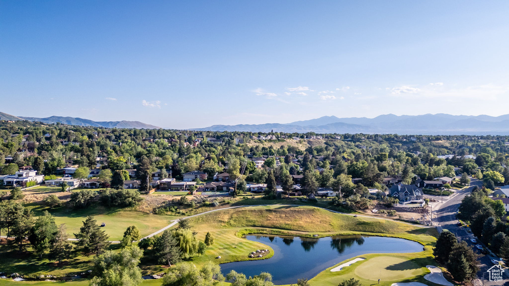 Aerial perspective of suburban area with a water and mountain view and a local golf course