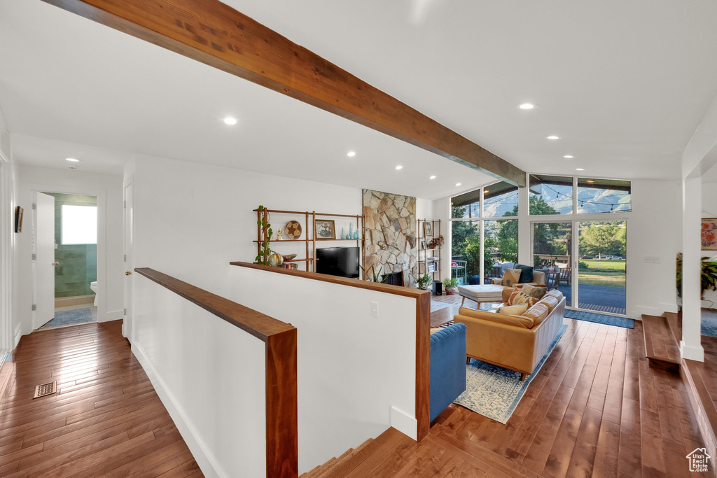 Living room with wood-type flooring, recessed lighting, and a fireplace