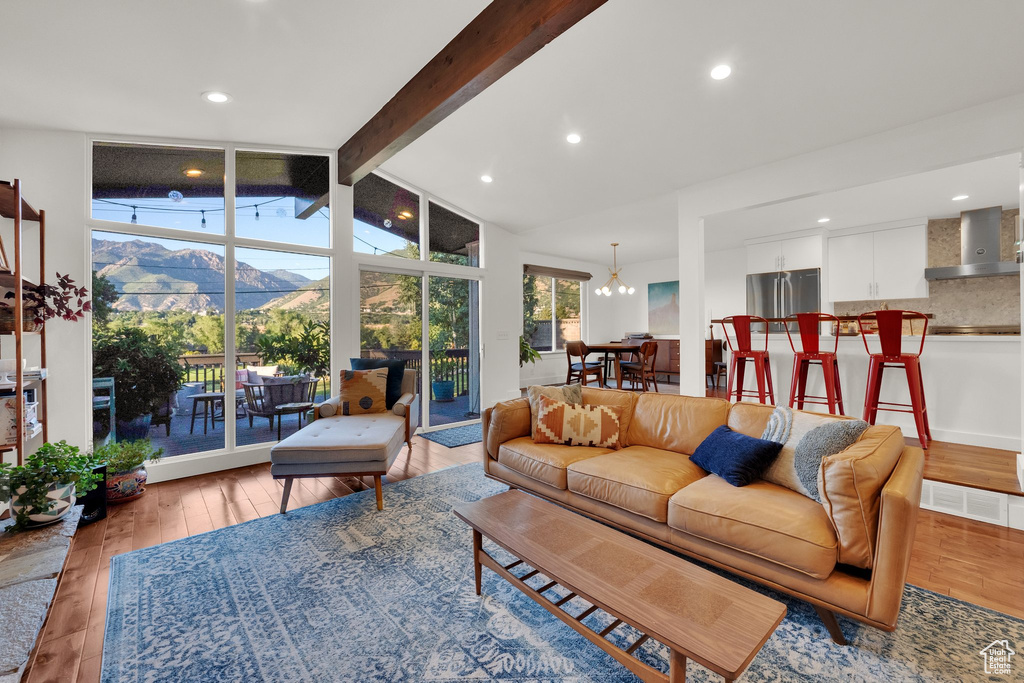Living room with a mountain view, light wood-style floors, a chandelier, and recessed lighting