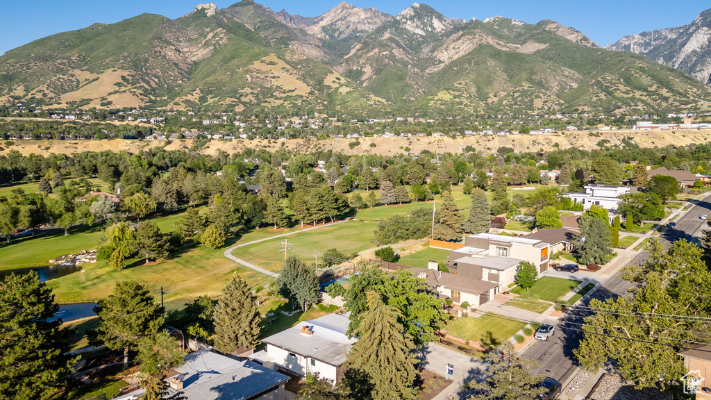 Aerial view of property and surrounding area featuring a mountain backdrop and nearby suburban area
