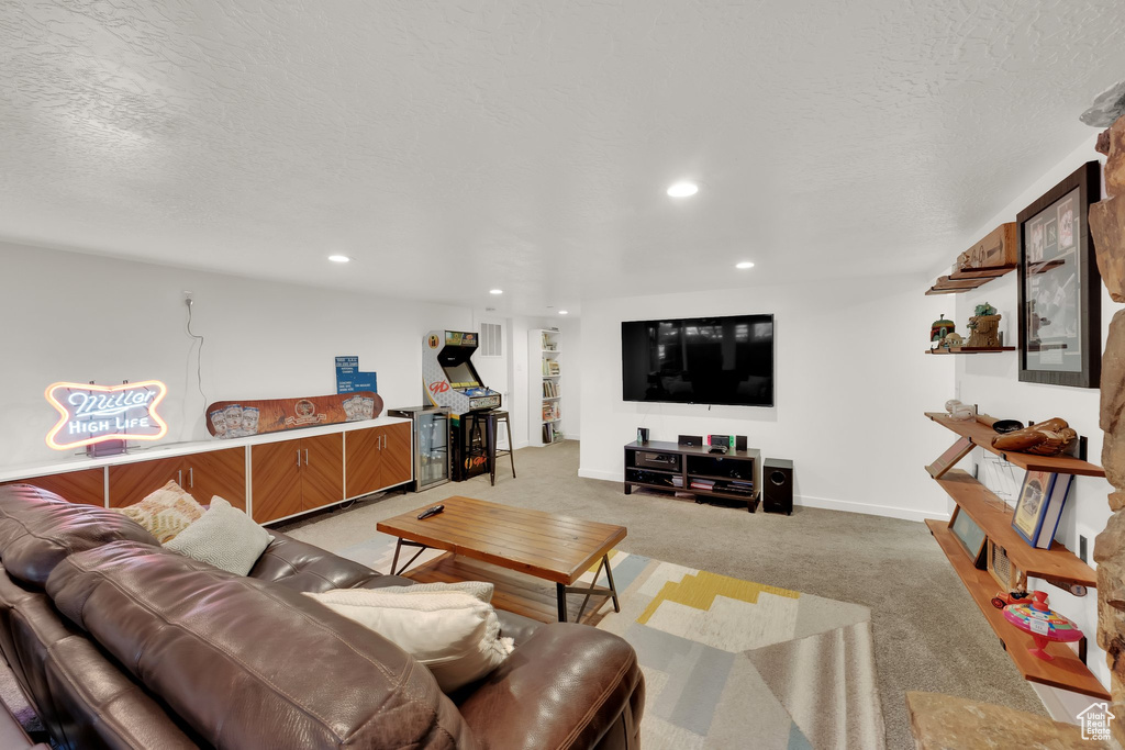 Living room featuring light colored carpet, recessed lighting, and a textured ceiling