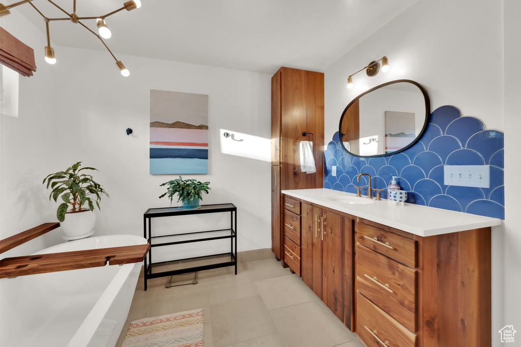 Bathroom with a soaking tub, vanity, and tile patterned floors