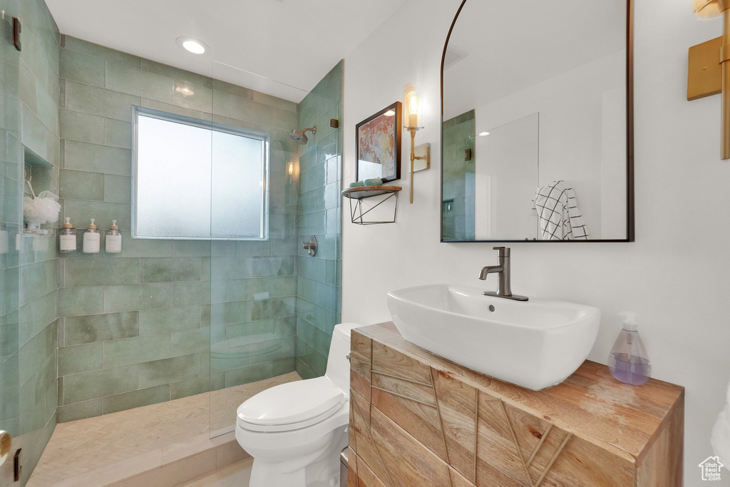 Bathroom with a walk in shower, vanity, and recessed lighting