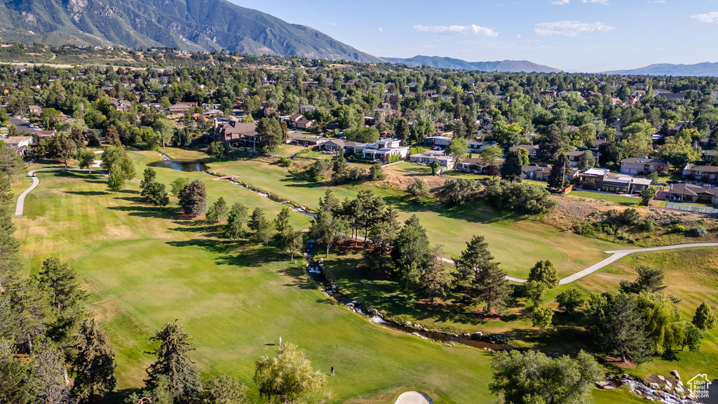 Aerial perspective of suburban area featuring a mountainous background and a golf course