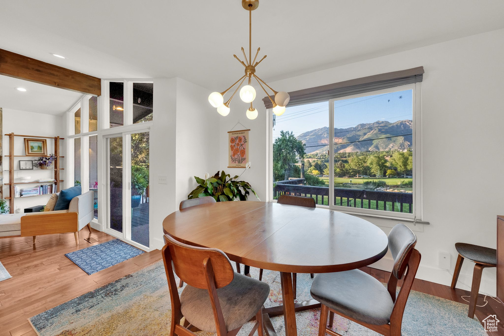 Dining area featuring plenty of natural light, wood finished floors, a mountain view, beam ceiling, and recessed lighting