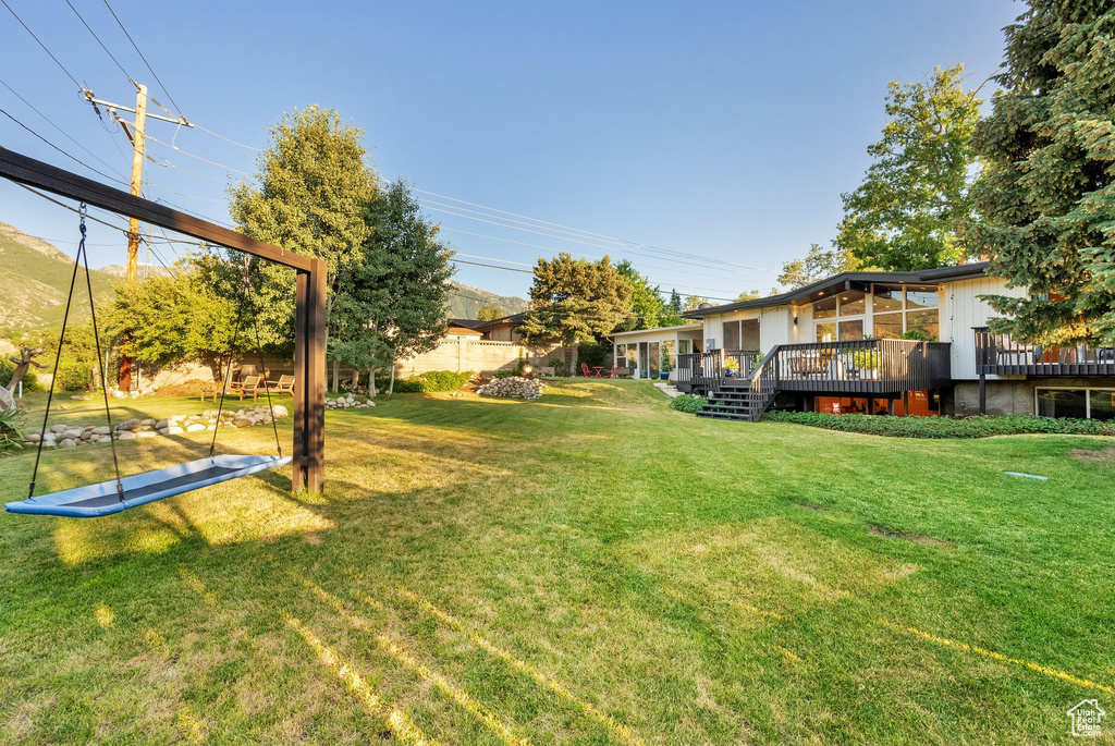 View of grassy yard with a wooden deck