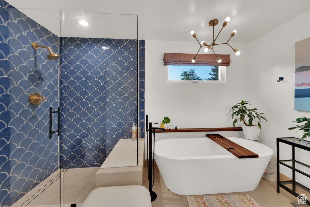 Bathroom with a freestanding bath, a chandelier, and a walk in shower