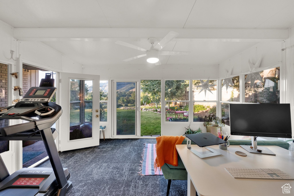 Sunroom featuring beamed ceiling and carpet floors