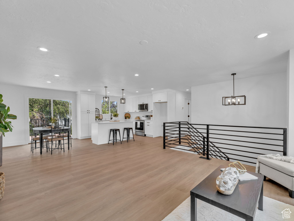 Living area featuring recessed lighting, light wood finished floors, and a chandelier