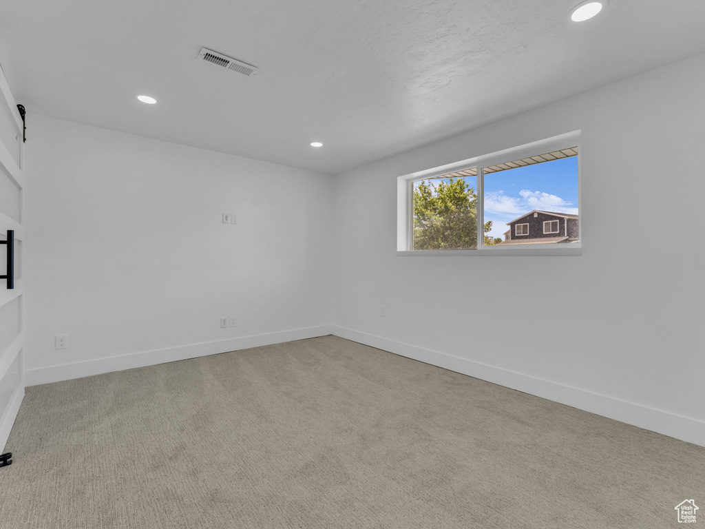 Carpeted empty room with recessed lighting