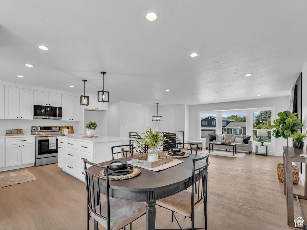 Dining room with light wood-style floors and recessed lighting