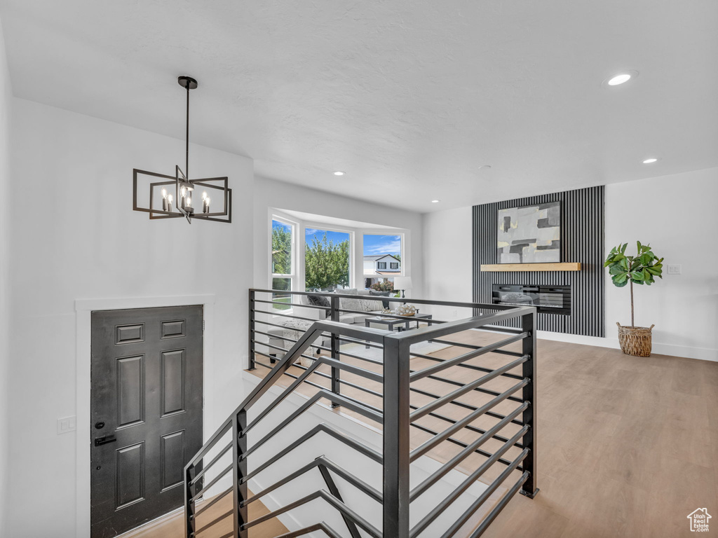 Corridor featuring an upstairs landing, light wood-style flooring, a chandelier, and recessed lighting