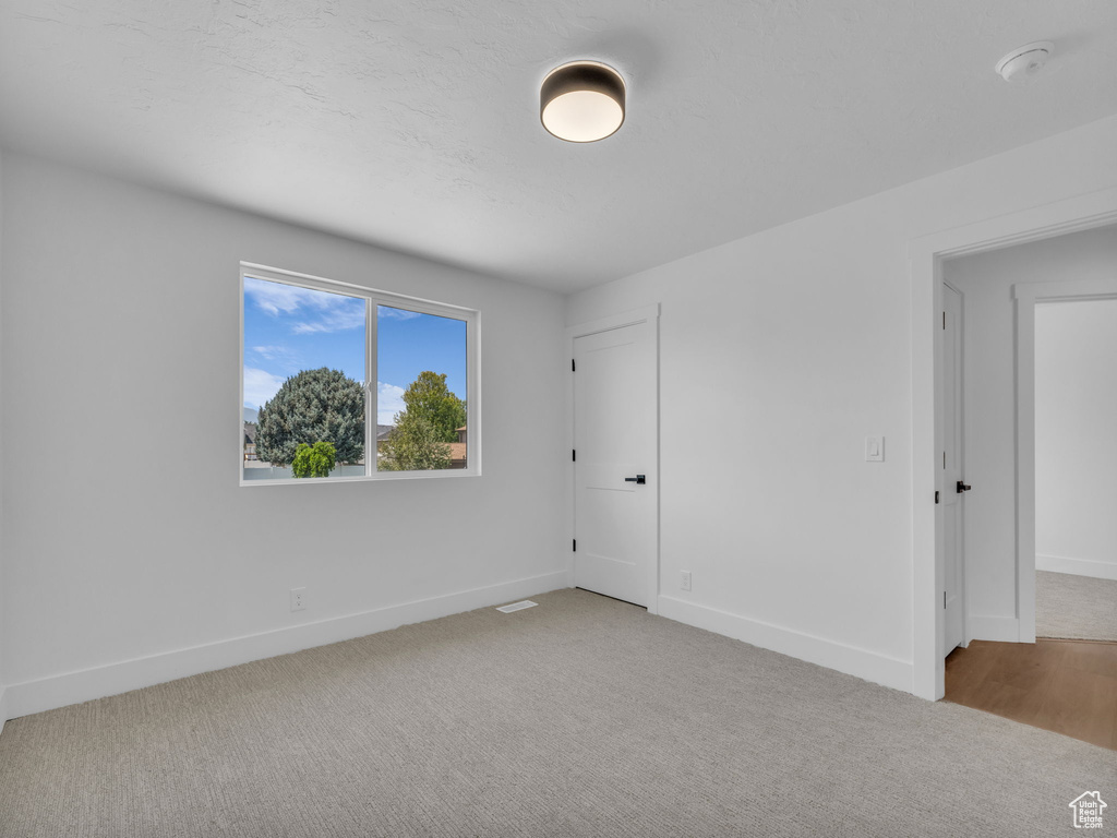 Unfurnished bedroom with carpet flooring and baseboards