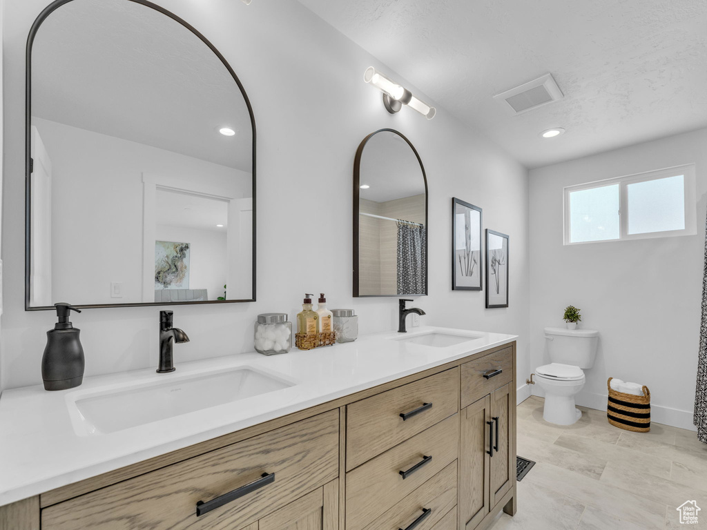 Full bath with double vanity, recessed lighting, and a shower with curtain