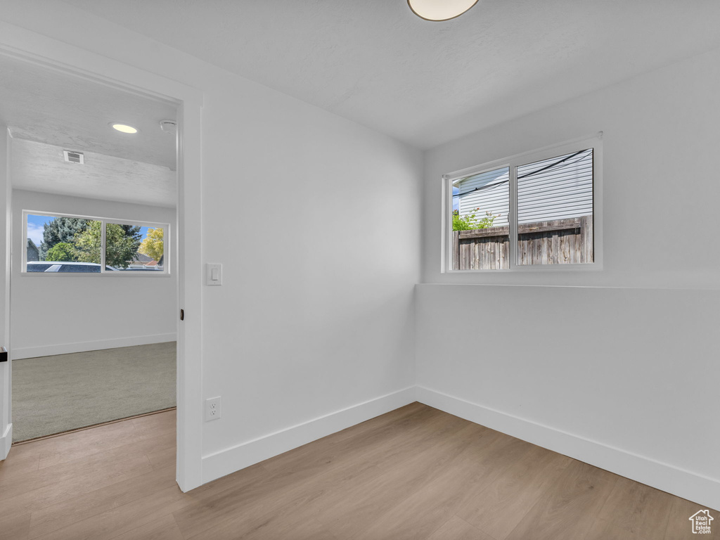 Empty room with plenty of natural light, light wood-style flooring, and recessed lighting