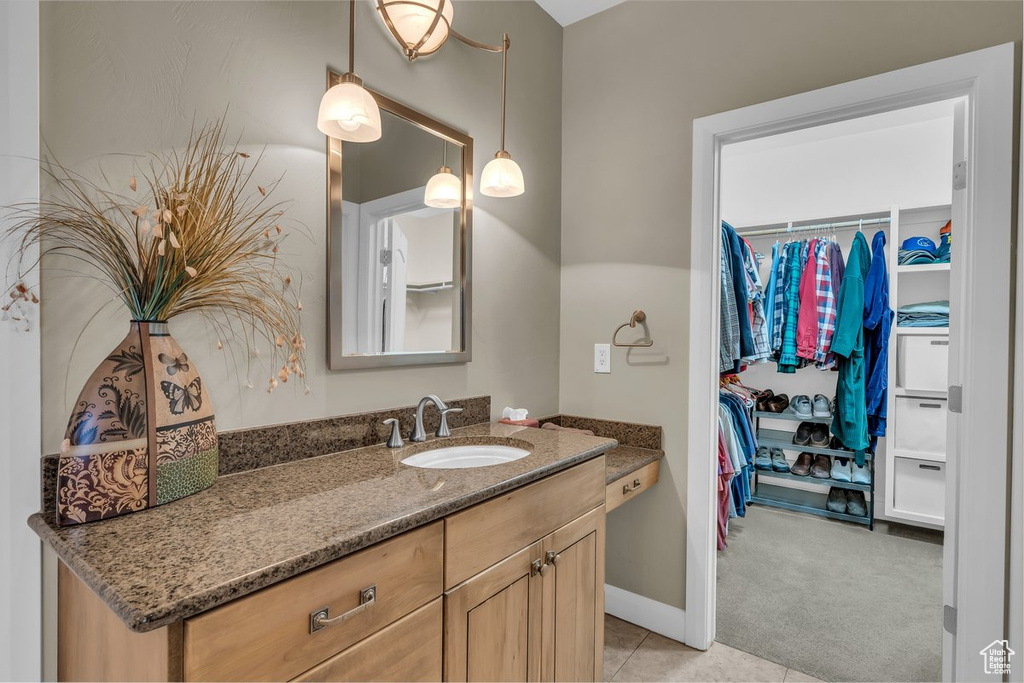 Bathroom featuring vanity, tile patterned floors, and a spacious closet