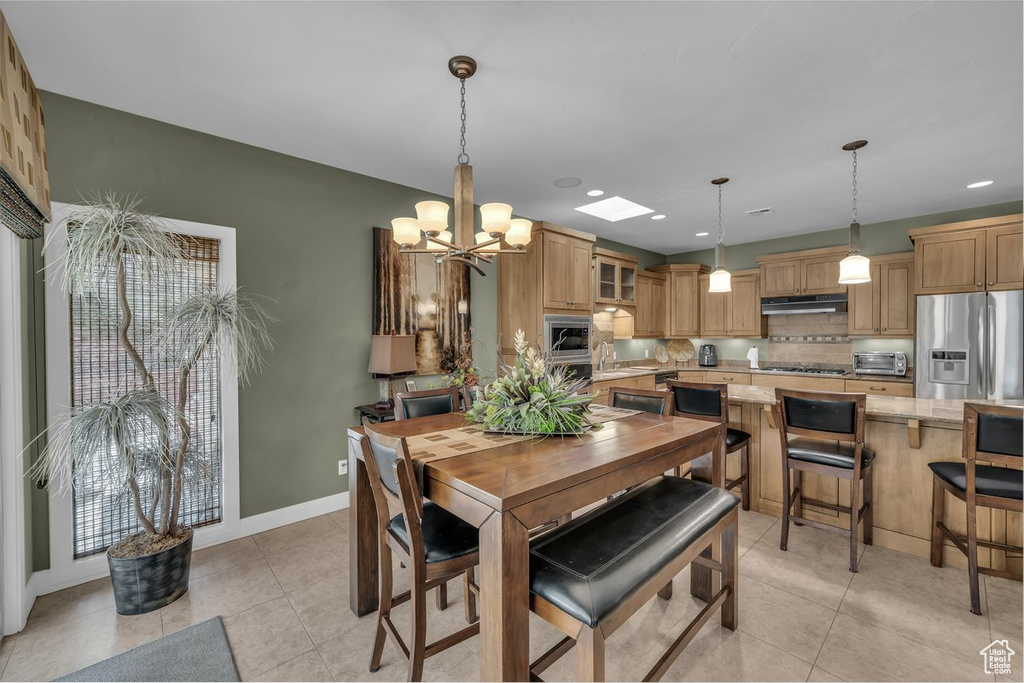 Dining space featuring a chandelier, light tile patterned floors, and recessed lighting