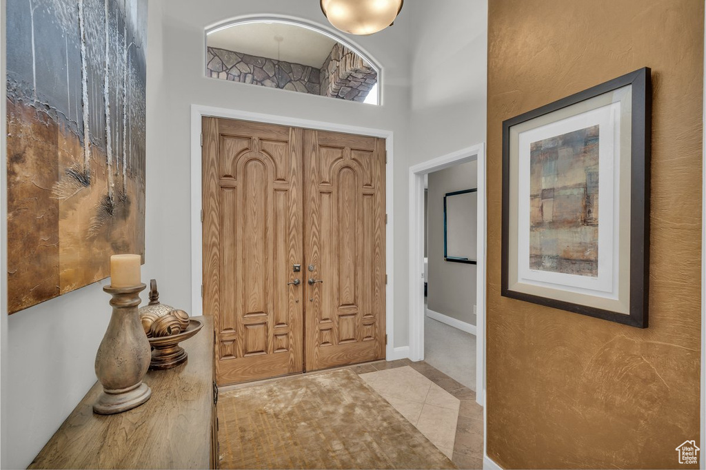 Foyer entrance with tile patterned flooring and baseboards
