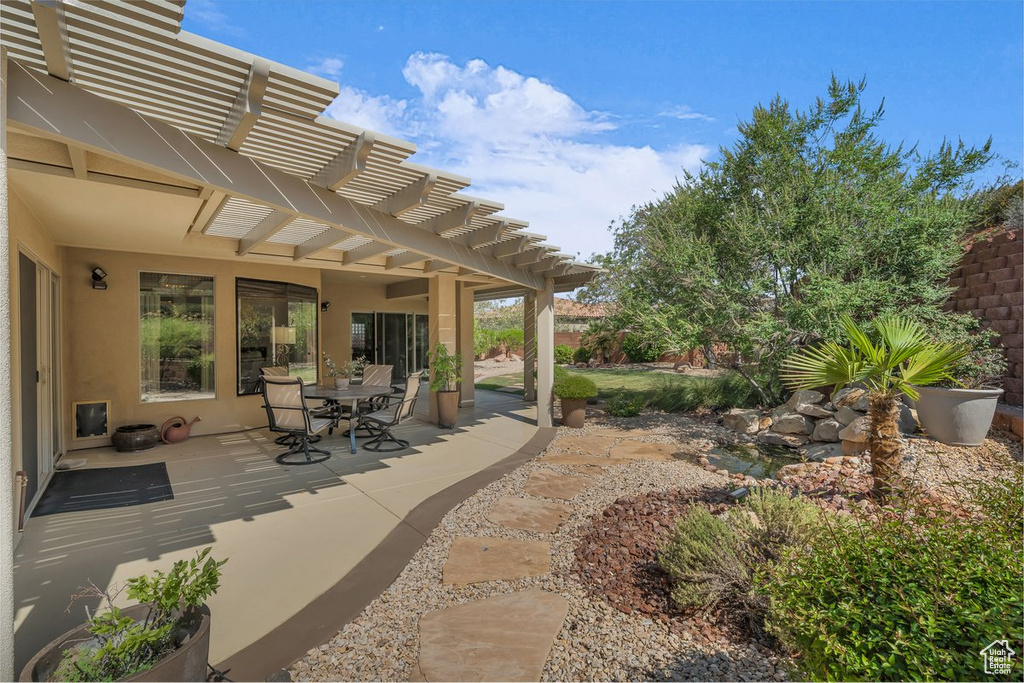 View of patio with a pergola and outdoor dining area