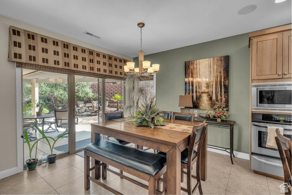 Dining room with a chandelier and light tile patterned floors