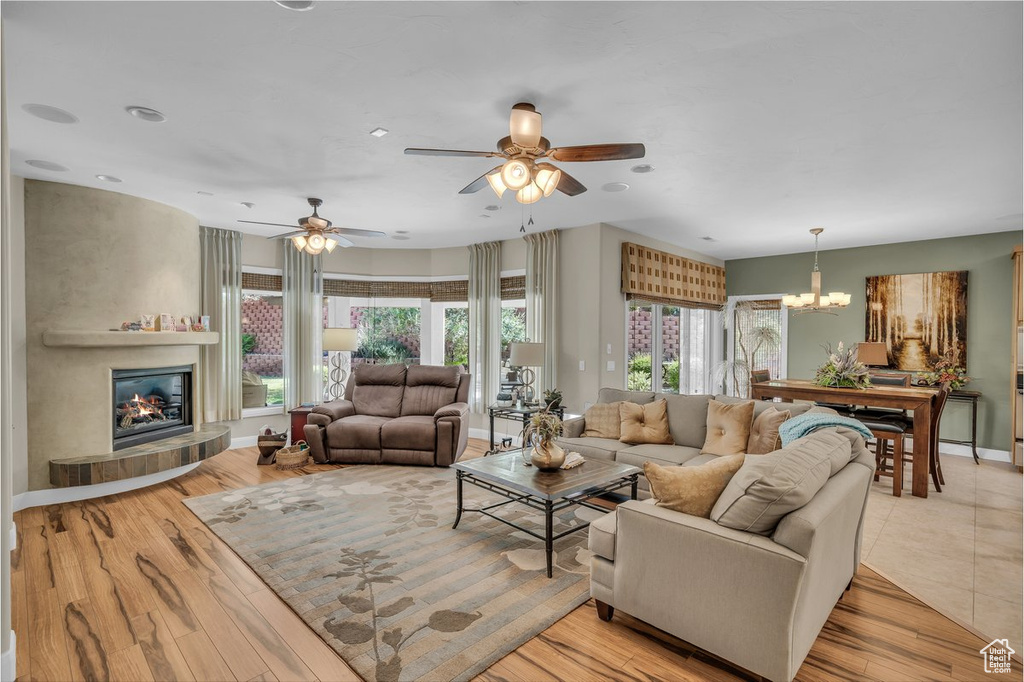 Living room with a chandelier, ceiling fan, a tile fireplace, and recessed lighting