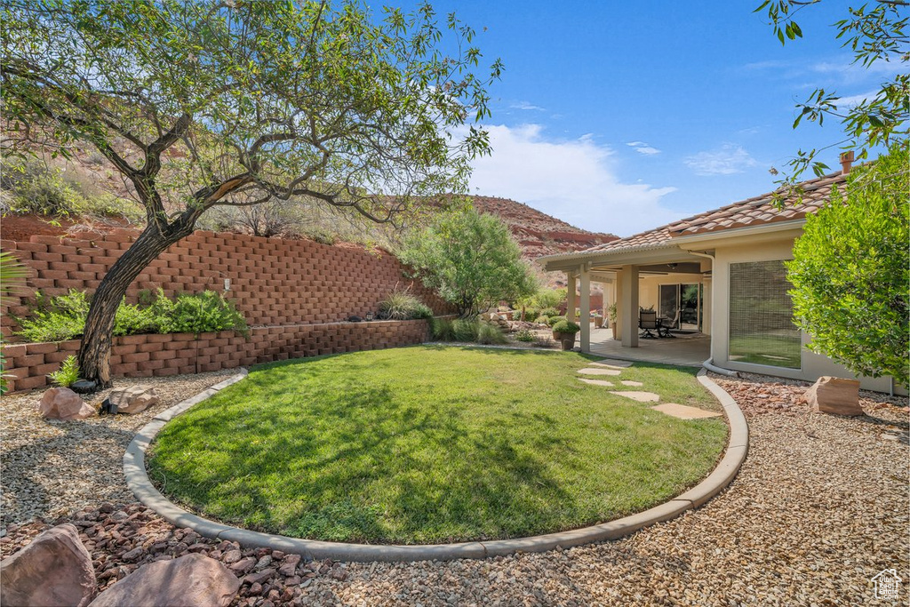 View of grassy yard with a patio area and a mountain view