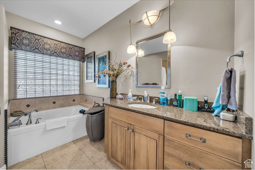 Full bathroom with tile patterned floors, vanity, and a garden tub