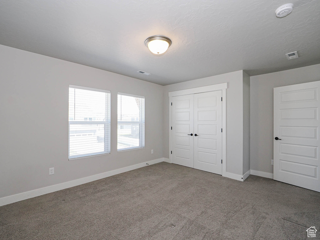 Unfurnished bedroom with carpet floors and a closet