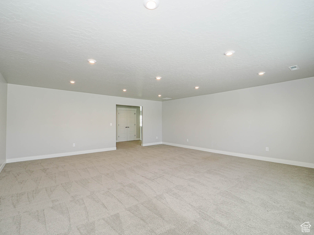 Empty room with recessed lighting and light carpet