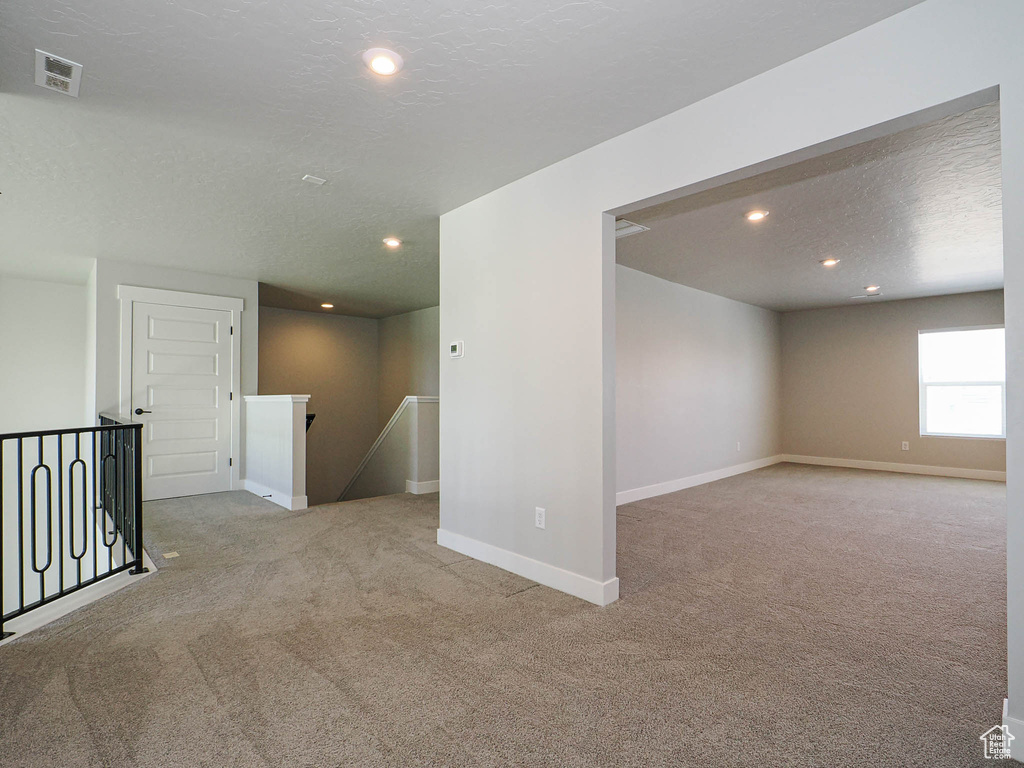 Unfurnished room with carpet floors, a textured ceiling, and recessed lighting